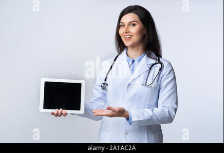 Smiling Medical Student Using Tablet Giving Presentation, Studio Shot Stock Photo