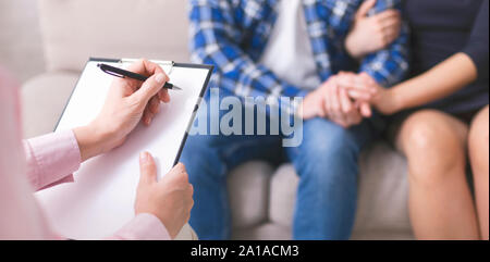 Therapist writing in notepad, couple bonding on background Stock Photo