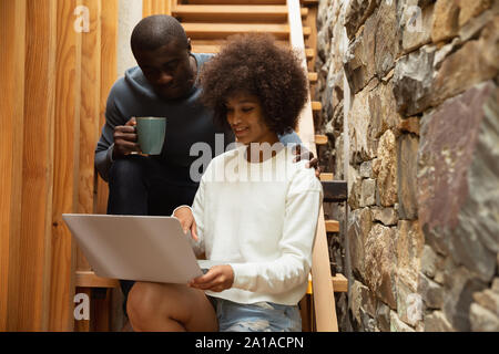 Couple drinking coffee and using laptop at home Stock Photo