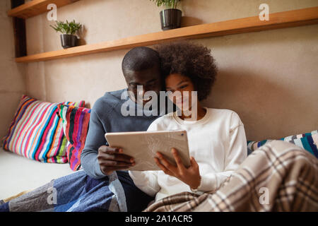Couple using a tablet on a sofa Stock Photo