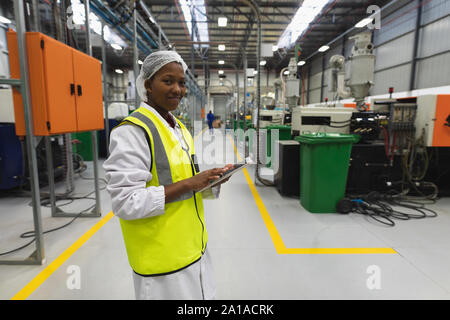Female factory worker in a large factory warehouse Stock Photo