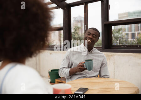 Couple drinking coffee and talking at a table Stock Photo