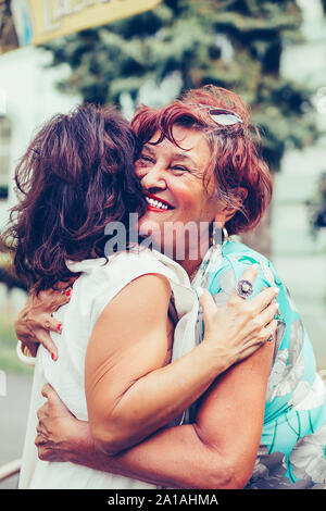 Senior female friends hugging, happy to see each other after many years friendship Stock Photo