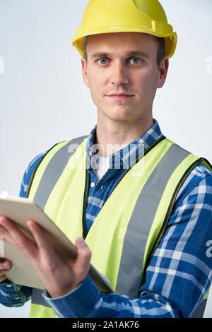 Studio Portrait Of Builder Architect Holding Clipboard Against White Background Stock Photo