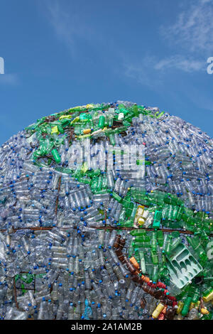 part of the globe made of plastic bottles and other plastic waste as a background dark blue sky. pictures taken vertically Stock Photo