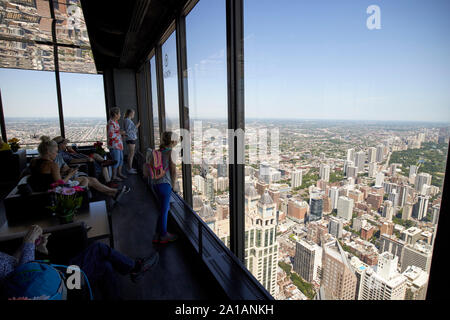 tourists looking out of the windows of the deck observation area of 360 chicago the john hancock center chicago illinois united states of america Stock Photo