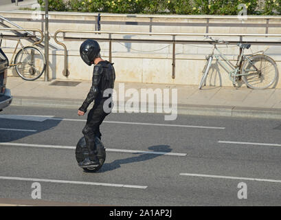 Italy, Lombardy, Milan, Man Riding His Electric Unicycle on Street Stock Photo