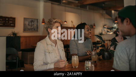 Young woman laughing with her friends in a bar Stock Photo