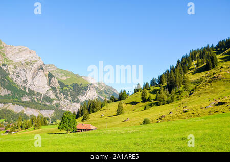 Beautiful Alpine landscape near Kandersteg in Switzerland captured in summer season. Green meadows, rocky hills. Swiss Alps, rocks and mountains. Trail leading to Oeschinensee lake. Stock Photo
