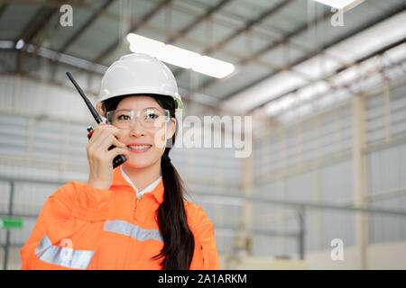 Engineer asian women using radio communication in factory. Stock Photo