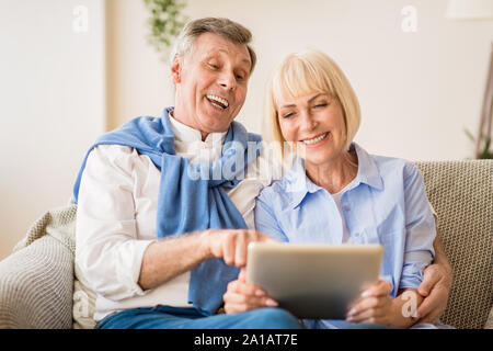 Loving senior couple websurfing on laptop computer Stock Photo