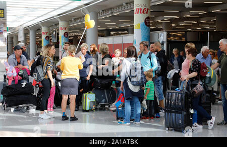 Palma De Mallorca, Spain. 25th Sep, 2019. A Neckermann employee stands next to several passengers at Palma de Mallorca Airport. The efforts to rescue the battered British tourism group Thomas Cook have failed. Thomas Cook daughters such as Neckermann Reisen and Öger Tours no longer sell tours. Credit: Clara Margais/dpa/Alamy Live News Stock Photo