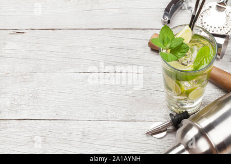 Cocktail utensils. Set of bar tools and mojito cocktail on wooden table. With copy space Stock Photo