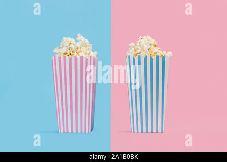 Popcorn in buckets on pink and light blue background Stock Photo