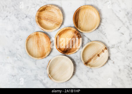 Small wooden plates on a marble table Stock Photo