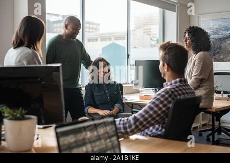 Diverse group of smiling designers meeting together in an office Stock Photo