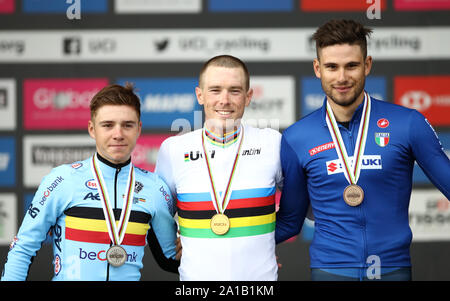 Australia's Rohan Dennis (centre) celebrates on the podium after winning gold alongside silver medalist Belgium's Remco Evenepoel (left) and bronze medalist Italy's Filippo Ganna during the Men's Elite Individual Time Trials from Northallerton to Harrogate. Stock Photo