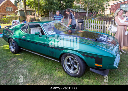 A 1971 Ford Mustang Mach 1 with classic dual scoop bonnet draws interest at a vintage car show in Belbroughton. Stock Photo