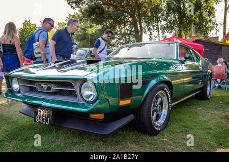 A 1971 Ford Mustang Mach 1 with classic dual scoop bonnet draws interest at a vintage car show in Belbroughton. Stock Photo