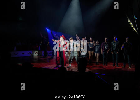 circus performers under tent in spotlights Stock Photo