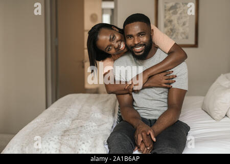 Affectionate African American couple wearing pajamas sitting on their bed Stock Photo
