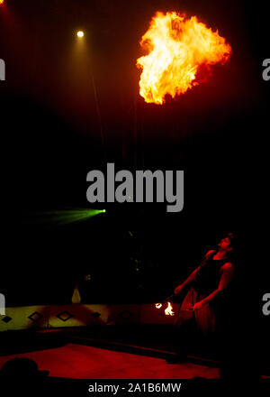 circus performers under tent in spotlights Stock Photo