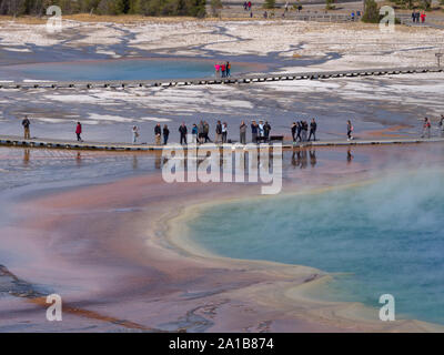 Tourists walking on boardwalk, Grand Prismatic Spring, Midway Geyser Basin, Yellowstone National Park, Wyoming, USA Stock Photo