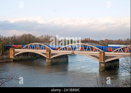 Elevated view of west side of Barnes Railway  Bridge, London SW13 over the River Thames with train crossing. Stock Photo