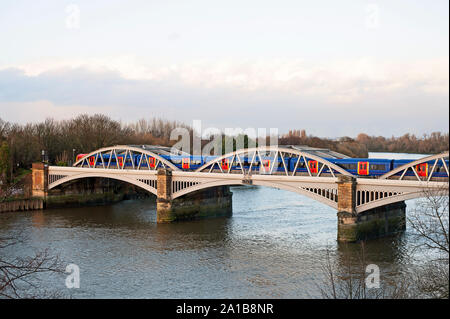 Elevated view of west side of Barnes Railway  Bridge, London SW13 over the River Thames with train crossing. Stock Photo