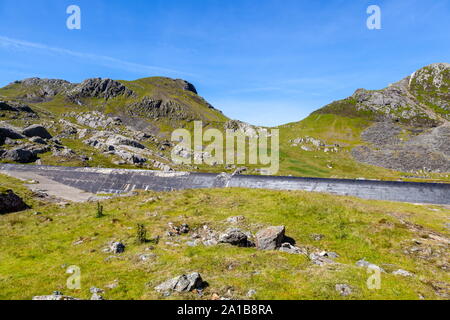 Looking over the overflow of Llyn Stwlan reservoir towards the summit of Moelwyn Bach, Snowdonia Stock Photo