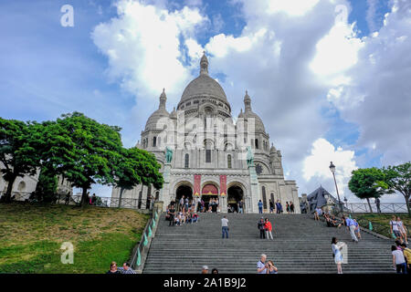 'Sacre-Coeur Church In The Clouds'- Image captured during a warm day morning stroll in Montmartre.The domes appear to be reaching to the clouds above. Stock Photo