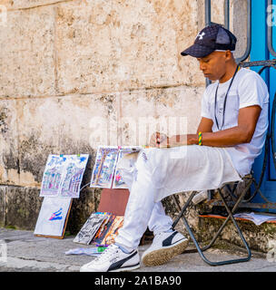 Havana, Cuba – January 2, 2019: Cuban artist drawing and selling his artwork in Old Havana, Cuba. Stock Photo
