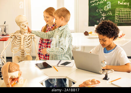 Attentive brunette boy sitting at his computer Stock Photo