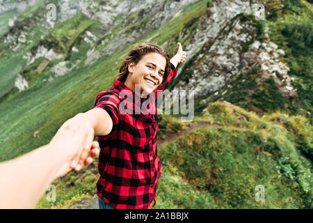 A beautiful woman holds the hand of a man and calls for adventures. Stock Photo