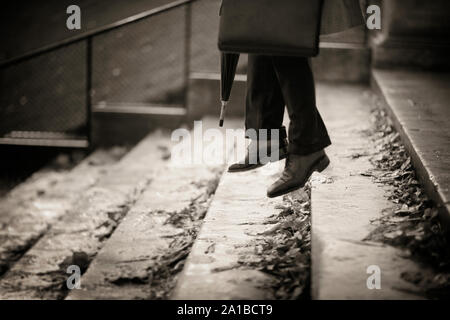 Legs of a man jumping down stone stairs. Stock Photo