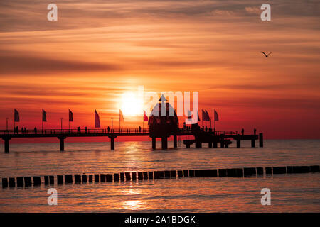 Sea bridge with diving gondola in Zingst in front of the beautiful sunset. Silhouette of the sea bridge before the skyline at the German Baltic Sea. Stock Photo