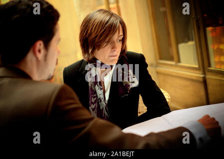 Anxious businesswoman looking at documents with a male colleague at a table. Stock Photo