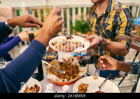 Group of diverse friends having dinner al fresco in urban setting Stock Photo