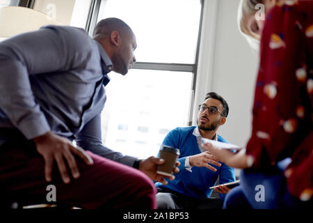 Multi-ethnic team of creative millenials collaborating on a brainstorm project Stock Photo