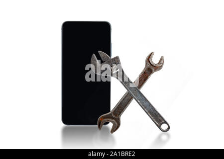 Cell phone repair concept. Cell phone, wrenches on a white background. Stock Photo