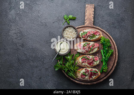 Roast beef on crusty bread with mayo and rocket, copy space. Stock Photo