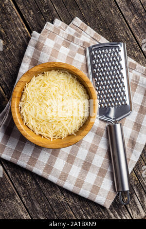 Tasty grated cheese. Parmesan cheese and cheese grater. Top view. Stock Photo