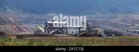 A Butte, Montana mining operation set at the base of a quarry is seen in the afternoon light. Stock Photo