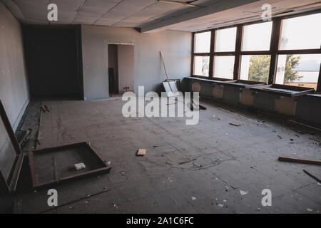 Dirty empty rooms, with broken windows and furniture, in an abandoned building. Stock Photo