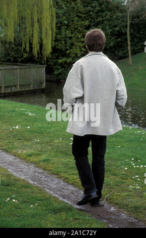 middle aged man walking down path Stock Photo