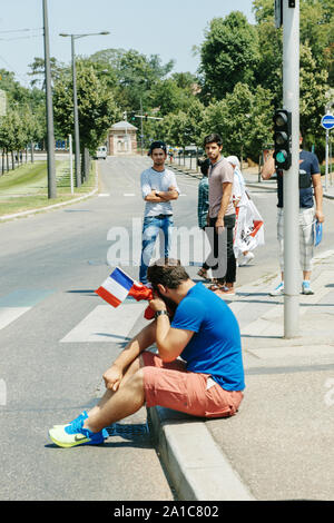 STRASBOURG, FRANCE - JULY 11, 2015: Protestor holding french flag cries after being pepper sprayed - Uyghur human rights activists participate in a demonstration to protest against Chinese government's policy in Uyghur Stock Photo