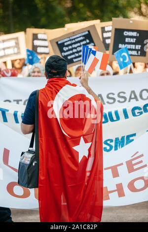 STRASBOURG, FRANCE - JULY 11, 2015: Man wearing Turkey flag and holding French flags - Uyghur human rights activists participate in a demonstration to protest against Chinese government's policy in Uyghur Stock Photo