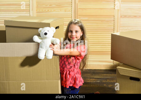 Only true friend. Girl child play with toy near boxes. Move out concept. Packaging things. Stressful situation. Divorce and separation. Family problem. Prepare for moving. Moving out. Moving routine. Stock Photo