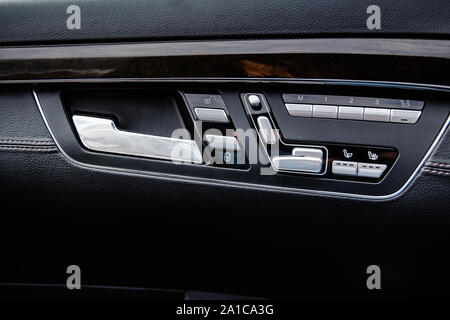 opening handle and control mechanisms on the door trim of a business class car with shallow depth of field Stock Photo