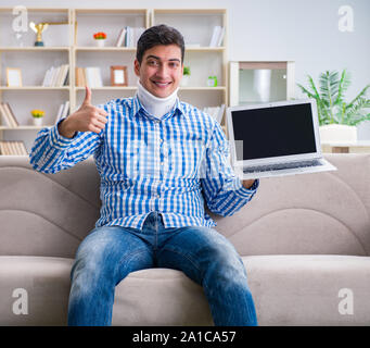 The man freelancer in a cervical collar neck brace working from home Stock Photo